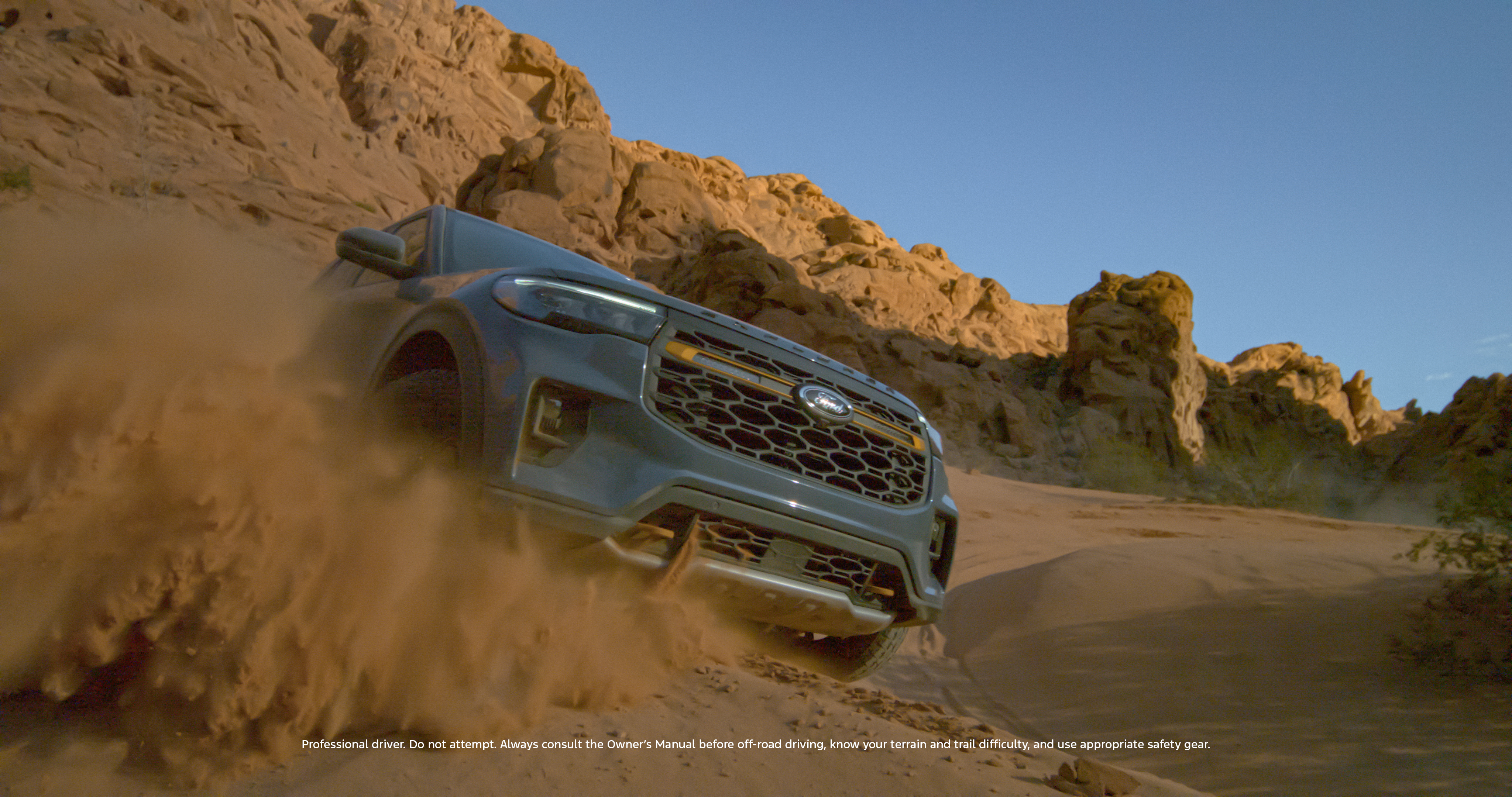 A Ford Explorer kicks up dirt on an off-road trail.